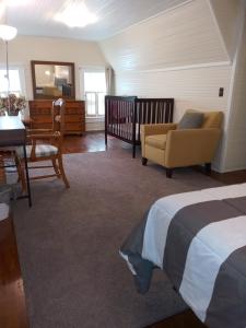 a bedroom with a bed and a table and a chair at Brick House Retreat in Rockingham