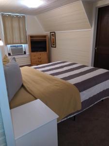 1 dormitorio con 1 cama grande y TV en Brick House Retreat, 