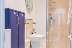 Un baño con lavabo, inodoro y ducha. en The Loft at Emperor Court by Bloom Stays, en Canterbury