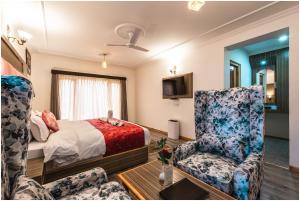 Habitación de hotel con 1 cama y 2 sillas en Sangaylay palace en Leh