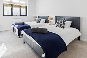 twee bedden in een kamer met blauw en wit bij Stunning Coastal Apartment in Maidencombe with Sea Views & Garden in Stokeinteignhead