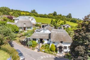 an aerial view of a house with a thatched roof at Stunning Coastal Apartment in Maidencombe with Sea Views & Garden in Stokeinteignhead