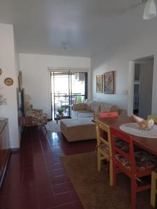 un soggiorno con tavolo e divano di Apartamento aconchegante perto da praia a Caraguatatuba