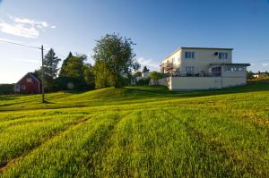 a white house on a grassy field next to a house at Villa Sisu in Överkalix