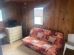 ein Wohnzimmer mit einem Sofa und einem Schreibtisch in der Unterkunft Bungalow confortable proche de la mer in Linguizzetta