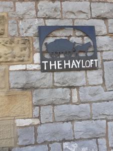 a sign on a brick wall that says the hydrat at The Hayloft in Hartington