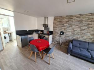 sala de estar con sofá azul y mesa roja en Appartement 60m2 rdc avec jardin en Saint-Génis