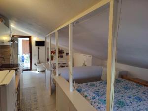 Un pequeño dormitorio con una cama y una cocina. en Ulivo, en Quartu SantʼElena