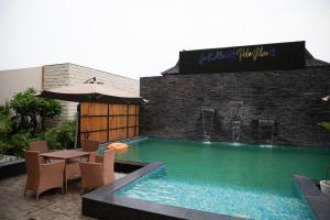 a swimming pool with a table and chairs and an umbrella at Palm Villas in Amritsar