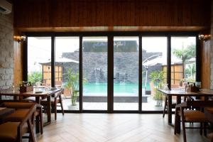 a restaurant with tables and chairs and a pool at Palm Villas in Amritsar