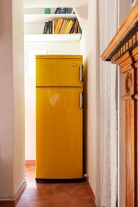 un réfrigérateur jaune dans un couloir avec une étagère dans l'établissement Suite Via Torino, à Milan