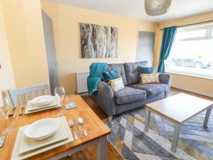 a living room with a couch and a table at The Bungalow in Abergele