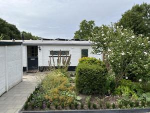 una casa blanca con un jardín delante de ella en House in a quiet location in Zeeland 2 en Bruinisse