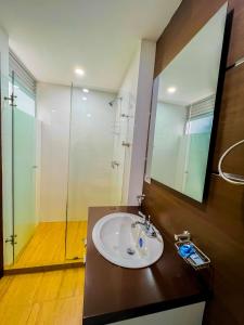 a bathroom with a sink and a glass shower at HotelSuizaApartamentos in Ipiales