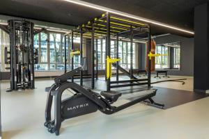 un gimnasio con cinta de correr y simulador en Flightgate Munich Airport Hotel, a member of Radisson Individuals en Hallbergmoos