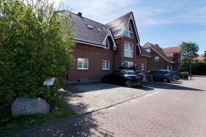 een huis met een auto ervoor geparkeerd bij Apartmenthaus Tiemann Wohnung 3 in Kellenhusen