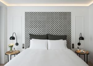 sypialnia z dużym białym łóżkiem i dwoma stołami w obiekcie Serras Barcelona w Barcelonie