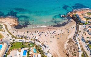 an aerial view of a beach with a crowd of people at Oleza Garden - Laguna Rosa - Playa Flamenca - Pool & Garden View. in Playa Flamenca