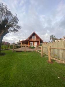 una casa con una valla de madera frente a un patio en Cabana no Vale dos Vinhedos en Bento Gonçalves
