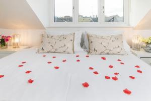 Una cama blanca con corazones rojos. en The Sky Penthouse, en Winchester