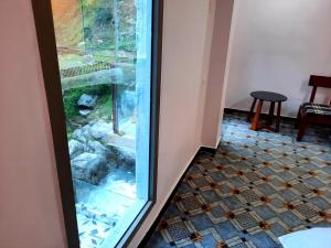 a room with a glass door and a tiled floor at Blue Water Resort Kalam in Kārandūkai