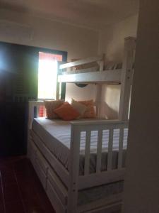 カラグアタトゥーバにあるApartamento aconchegante perto da praiaの白い二段ベッド(枕付)が備わります。
