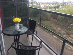 una mesa y sillas en un balcón con flores amarillas en Departamento Mareta Mazatlán, en Mazatlán
