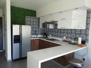 a kitchen with a white refrigerator and wooden cabinets at Departamento Mareta Mazatlán in Mazatlán
