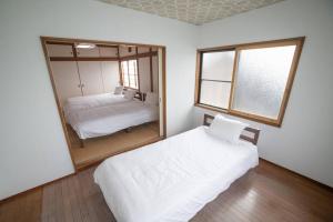 a bedroom with two beds and a large mirror at Tomoeドットコム3 in Hakodate