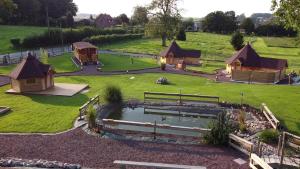 een luchtzicht op een park met huizen en een vijver bij La Claud'Roulotte - Gîte du Moulin 62130 Pierremont in Pierremont