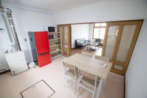 a kitchen with a table and a red refrigerator at Tomoeドットコム3 in Hakodate