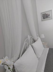 1 dormitorio blanco con 1 cama con cortinas blancas en Anezinas place, en Perissa