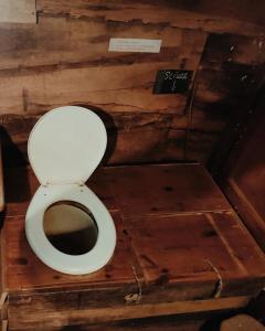 uma casa de banho com WC num quarto de madeira em La Cabane des Trappeurs em Crépy-en-Valois