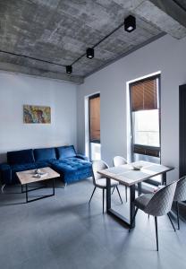 a living room with a blue couch and a table at Apartamenty Dworcowa 60 in Gliwice