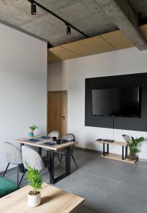 a living room with a table and a tv on the wall at Apartamenty Dworcowa 60 in Gliwice