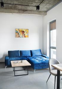 um sofá azul numa sala de estar com uma mesa em Apartamenty Dworcowa 60 em Gliwice