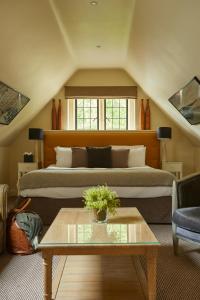 a living room with two beds and a coffee table at The Slaughters Country Inn in Lower Slaughter