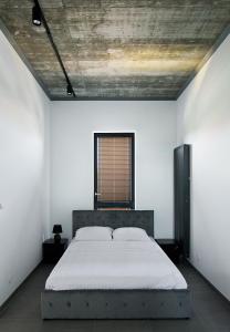 a bedroom with a bed in a white room at Apartamenty Dworcowa 60 in Gliwice