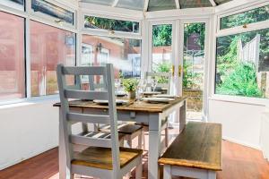 een eetkamer met een tafel, stoelen en ramen bij Private Parking&Garden&Contractor&Families in Ipswich