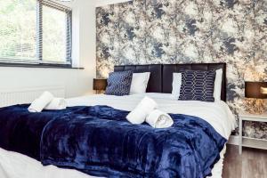 sypialnia z dużym łóżkiem i niebieskim kocem w obiekcie Private Parking&Garden&Contractor&Families w mieście Ipswich