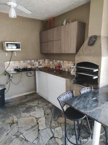 a kitchen with a counter and a table with chairs at Casa de Férias Praia Grande in Praia Grande