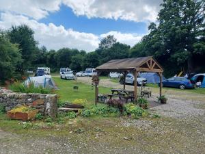 a picnic shelter with a picnic table in a park at 2 Bed Pod Cabin-Sleeps 2-Pets-Garden-Mtn View in Omagh +3 photos