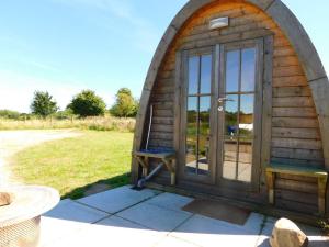 uma pequena casa de hobbit de madeira com uma porta de vidro em Cosy Pod-Cabin near beautiful landscape in Omagh em Omagh