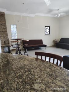 a living room with a table and chairs and a piano at Casa de Férias Praia Grande in Praia Grande