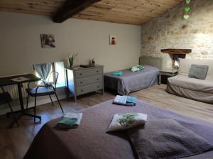 um quarto com duas camas, uma mesa e um sofá em Les Chenets em Chenay