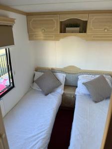 two beds in the back of a small room at Central Ingoldmells, Seaview 6 berth in Ingoldmells