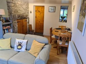 ein Wohnzimmer mit Sofa und Tisch in der Unterkunft North Wales Cosy Cottage with views near Eryri Snowdonia in Nantlle