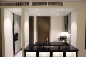 a kitchen with a black counter top in a room at Living Sensory 1-bed rental apartment unit with Pool in Lahore