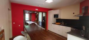 a kitchen with red walls and a table in it at La Diligence 
