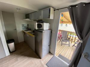 cocina pequeña con nevera y balcón en Mobilhome Santerre, en Châtillon-sur-Broué